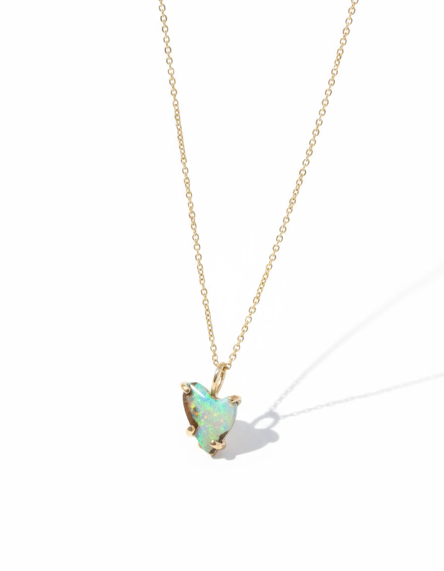 Necklace with a opal pendant on a black textured surface