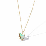 Necklace with a opal pendant on a black textured surface